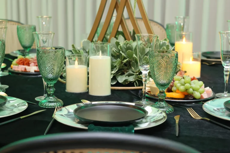 Detalle de mesa con copas verdes, velas y frutas