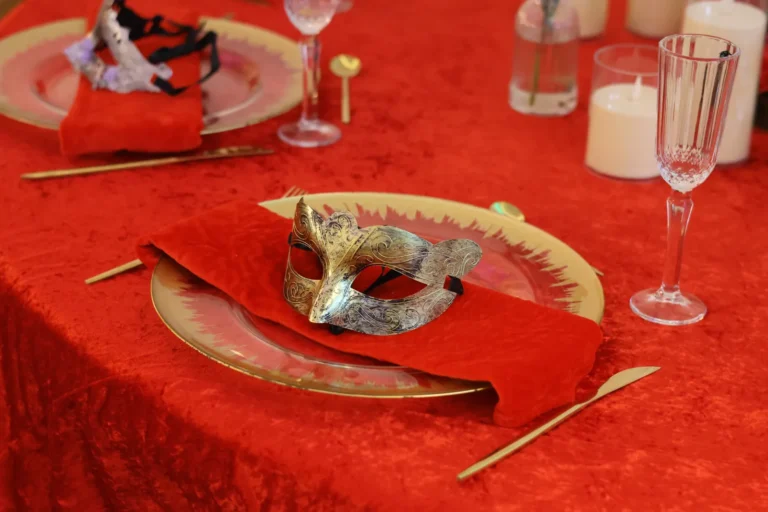 Mesa de gala con máscara dorada sobre mantel rojo