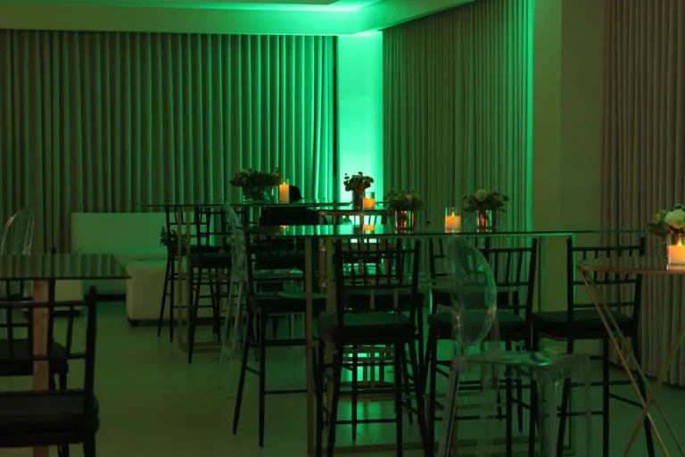 Salón amplio con mesas altas e iluminación verde
