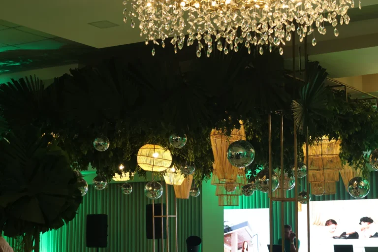 Techo decorado con follaje verde y lámpara de cristal